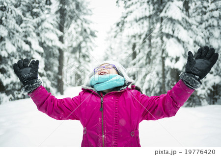 Little Girl Playing with Snow Outdoors in Winter Little Girl Playing with Snow Outdoors in Winter 19776420