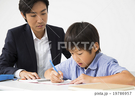 勉強する小学生の男の子と若い男性教師 19786957