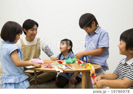 保育士の男性と折り紙をする子供たち 保育士の男性と折り紙をする子供たち 19786978