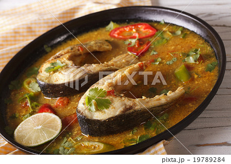 Spicy fish curry with vegetables close-up on plate 19789284