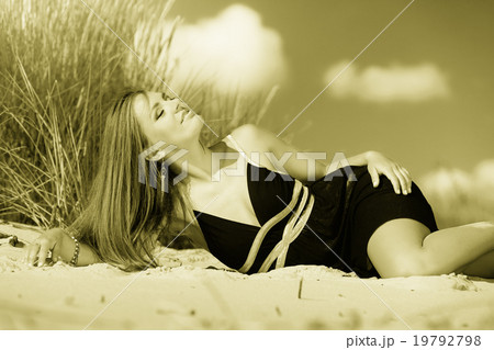 Woman sunbathing on beach. 19792798