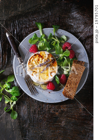 Baked Goat cheese with honey and raspberries Baked Goat cheese with honey and raspberries 19795701