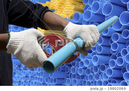 Worker cutting pvc pipe in construction site 19802069