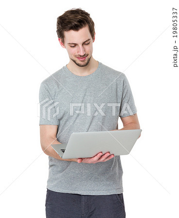 Smiling young man working on laptop Smiling young man working on laptop 19805337