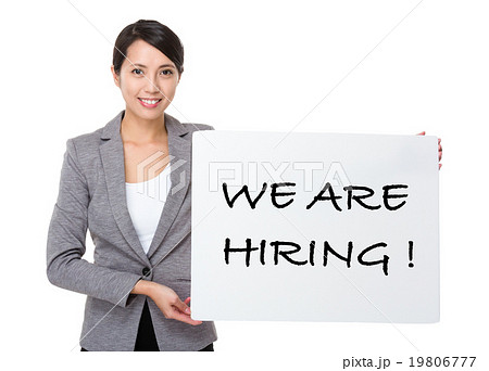Young businesswoman holding a placard showing with we are hiring 19806777
