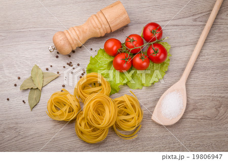 Pasta, tomatoes and pepper on a wooden background 19806947