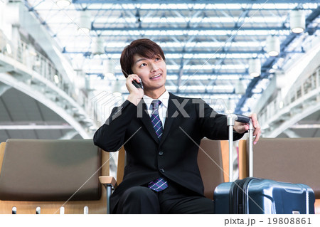 空港のロビーで電話をするビジネスマン 19808861