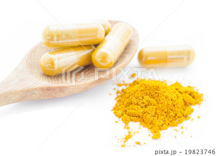 Turmeric powder and a wooden spoon. 19823746