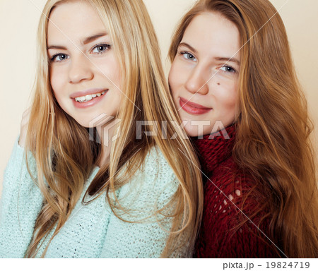 Two young girlfriends in winter sweaters indoors 19824719