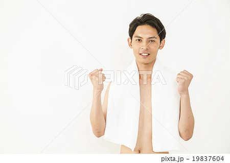 上半身裸でガッツポーズする若い男性の写真素材