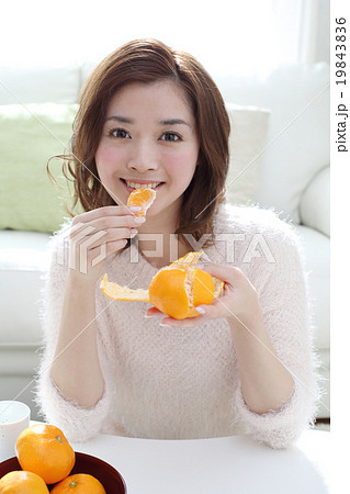 みかんを食べる若い女性の写真素材