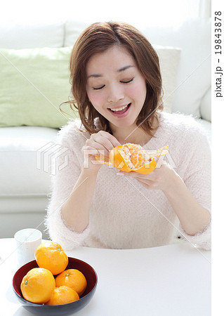 みかんを食べる若い女性の写真素材