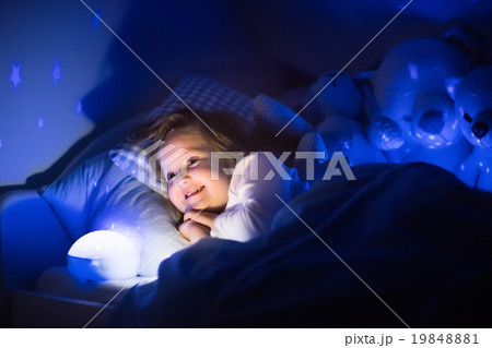 Little girl reading a book in bed Little girl reading a book in bed 19848881