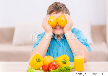 Chubby kid playing with oranges. 19849919