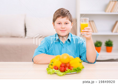 Chubby kid with juice and veggies.  19849920