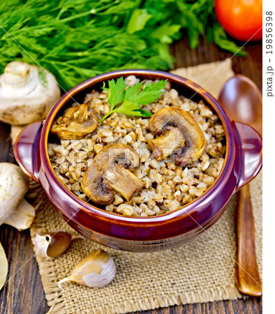 Buckwheat with champignons in clay bowl on sacking Buckwheat with champignons in clay bowl on sacking 19856398