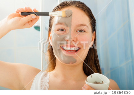 Woman applying mud facial mask Woman applying mud facial mask 19864850