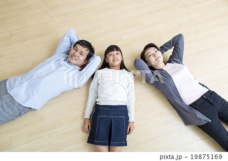 床に寝そべる3人の親子を俯瞰の写真素材