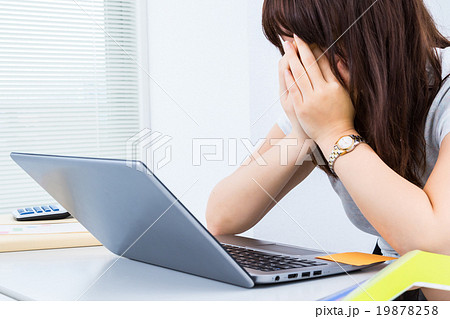 睡眠不足の女性社員　徹夜して眠い女性　疲れた人　アジア人の写真素材　パソコン　OL　白バック　 19878258