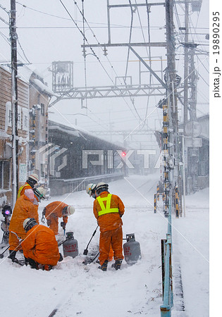 働く人 ポイントの雪をバーナーで溶かす保線員の写真素材