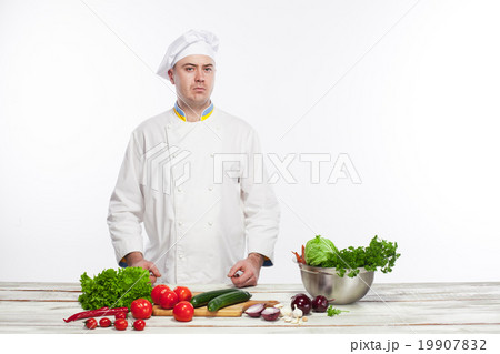 Chef cutting a green cucumber in his kitchen 19907832