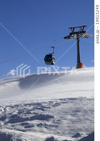 Gondola lift on ski resort at windy sun day 19915249