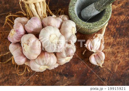 Garlic organic and mortar on wooden background Garlic organic and mortar on wooden background 19915921