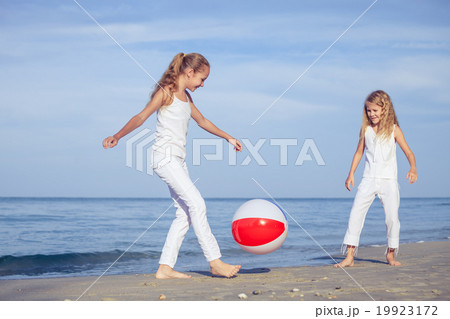 Two sisters playing on the beach at the day time. 19923172