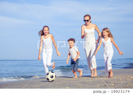 Mother and children playing on the beach at the day time. Mother and children playing on the beach at the day time. 19923174