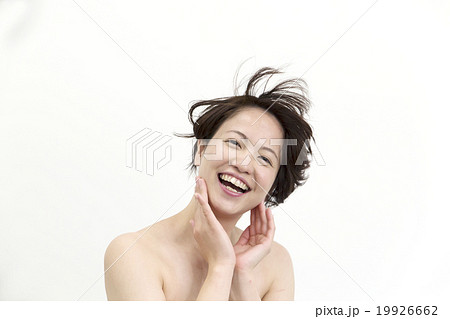笑顔の女性 ショートヘアー 風でなびく髪 カメラ目線 笑顔の写真素材