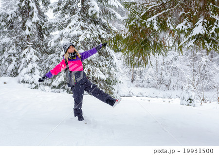 Blonde young woman standing in winter forest 19931500