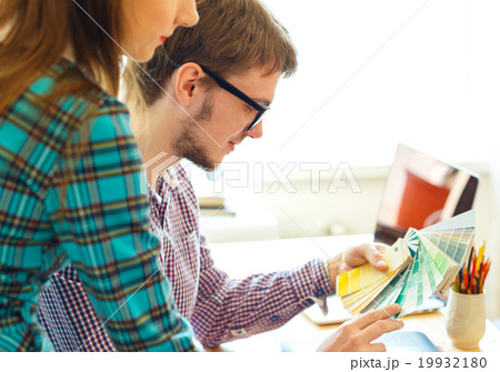 Young colleague - manand woman looking to a color paint palette 19932180