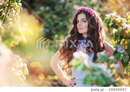 beautiful young woman in a spring park with wreath beautiful young woman in a spring park with wreath 19940047