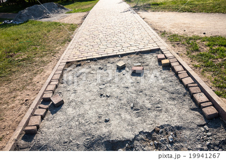 Paving the footpath with the tiled cubes. 19941267