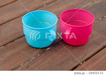 Colored cups on the wooden background 19950115