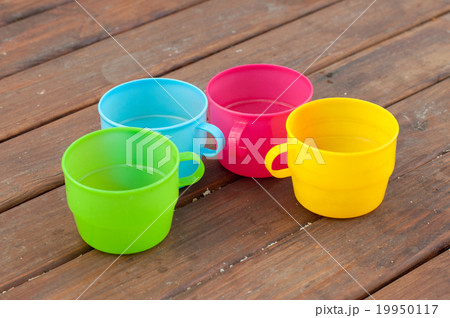 Colored cups on the wooden background Colored cups on the wooden background 19950117