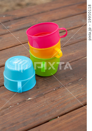 Colored cups on the wooden background 19950118