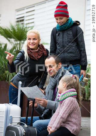 Parents with two kids and baggage with map . Parents with two kids and baggage with map . 19952719