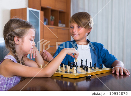Children playing chess at home. Children playing chess at home. 19952876