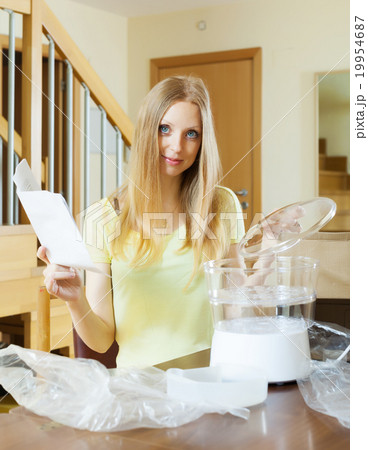 girl reading user manual for new electric steamer 19954687