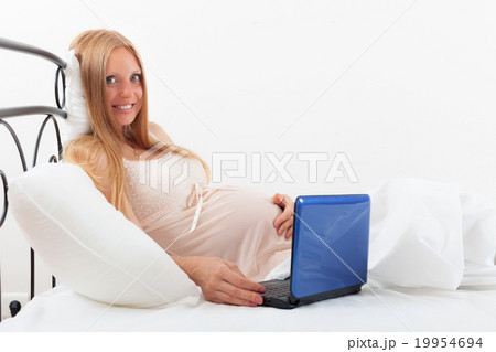 pregnancy woman in nightdress with laptop 19954694