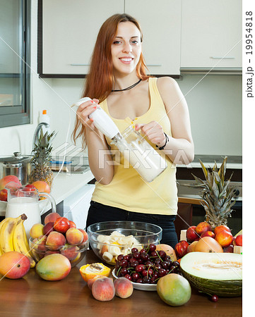 woman making fresh milkshake from fruits 19954818