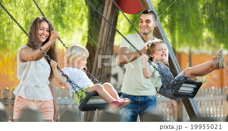 Parents with kids at swings 19955021