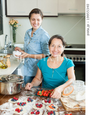 mother with daughter making berries dumplings 19955340