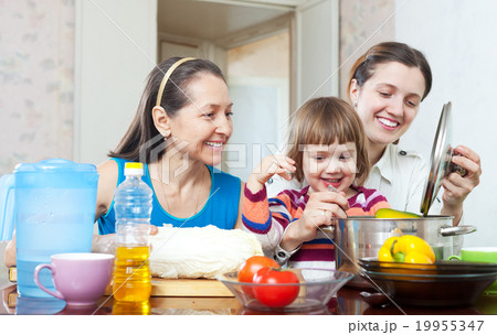 happy women with girl in kitchen at home 19955347