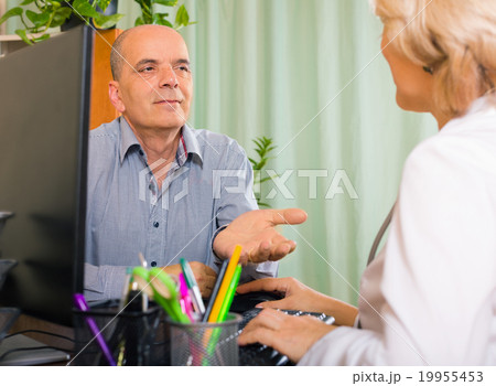 Elderly female doctor talking with mature male patient Elderly female doctor talking with mature male patient 19955453