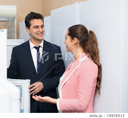 Satisfied customers looking at large fridges 19956015