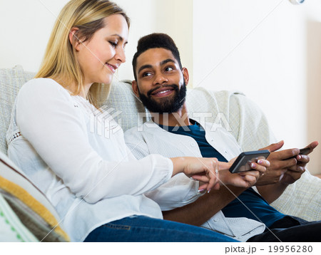 man and woman sitting on sofa 19956280