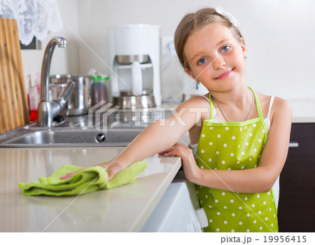 Girl polishing table top at home. 19956415