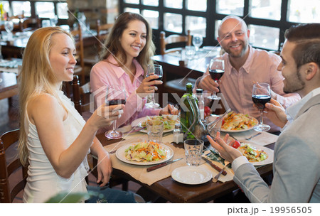Young people enjoying food at tavern 19956505